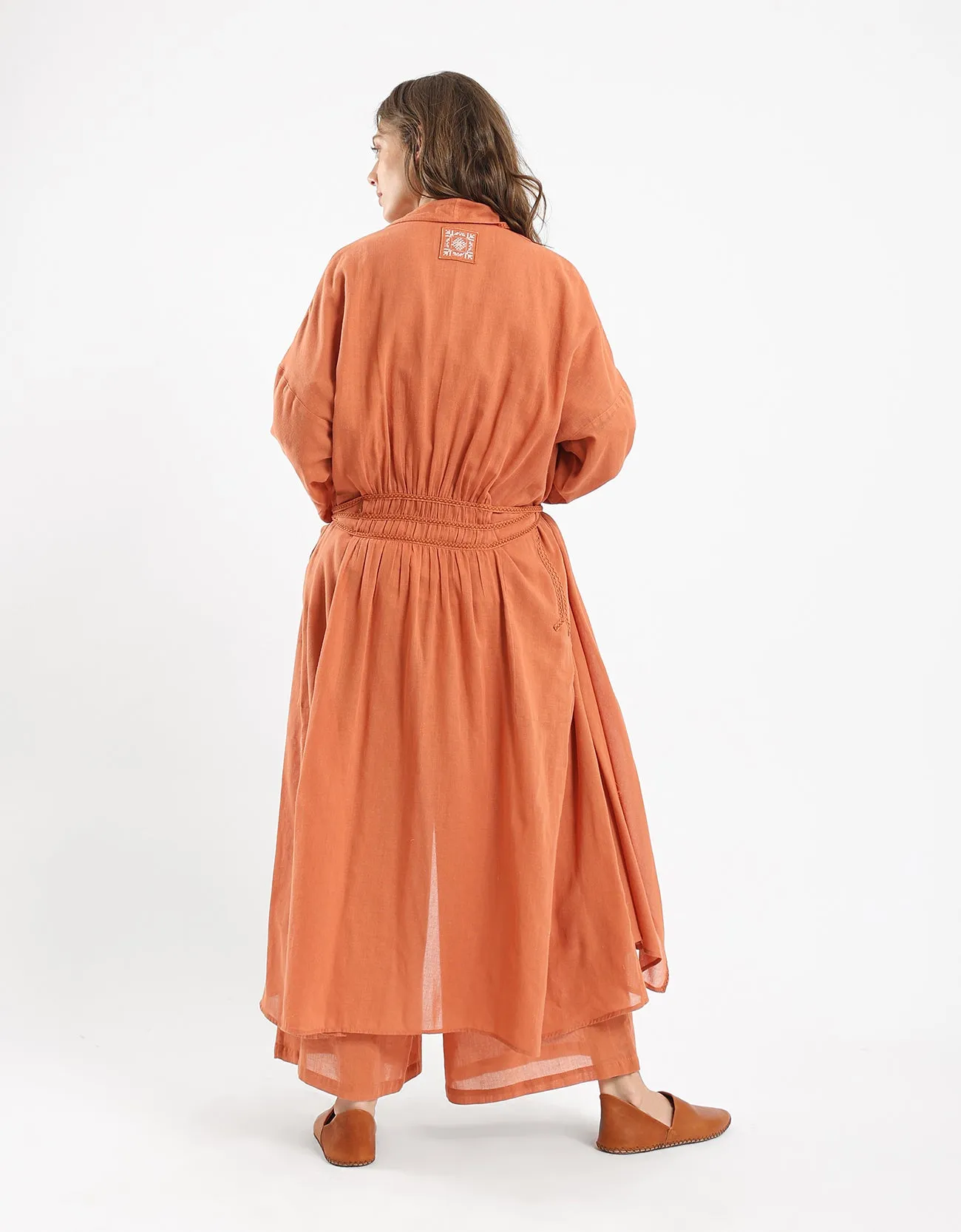 Long draped coat with decorative stitching details on the belt