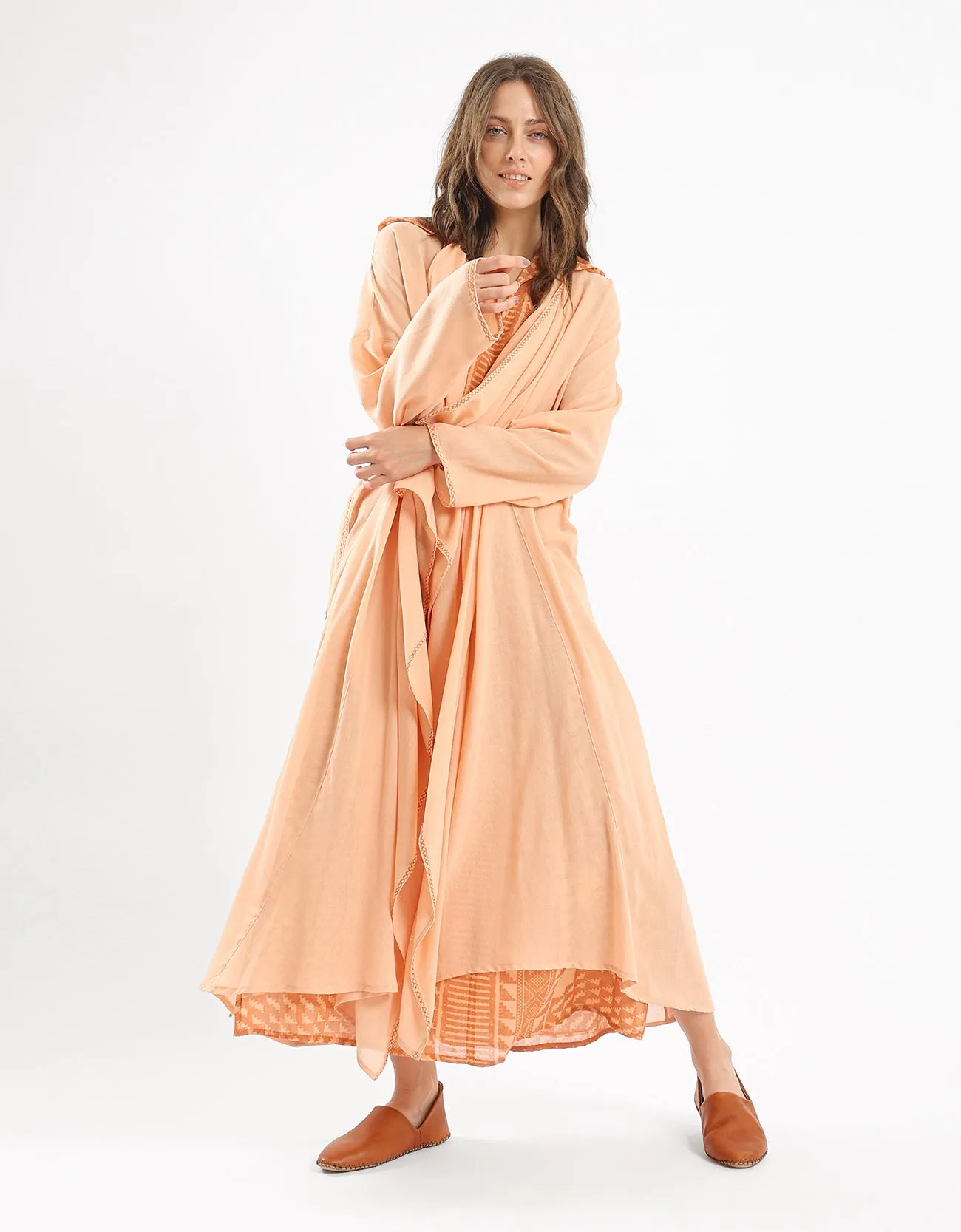 Long draped coat with decorative stitching details on the belt