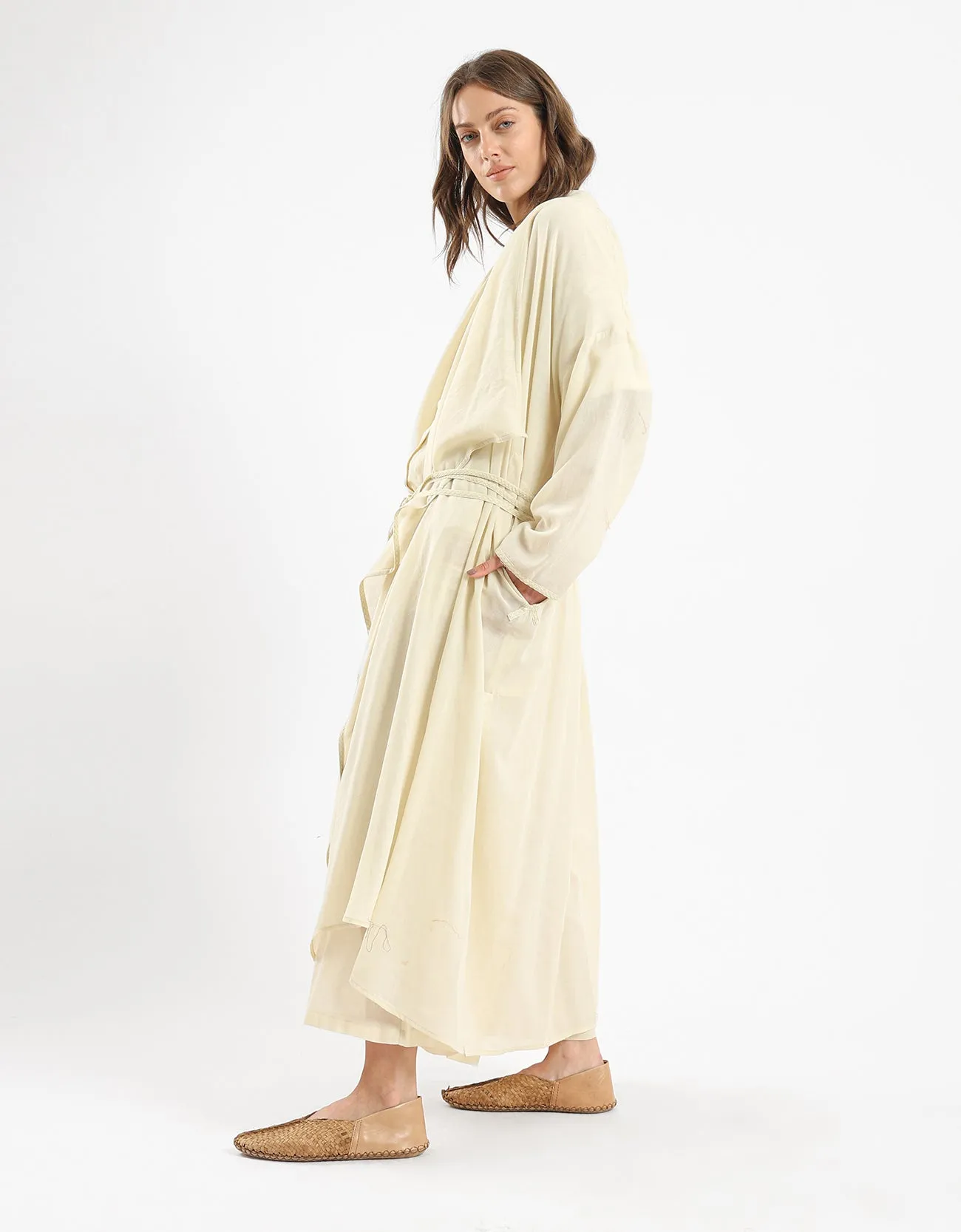 Long draped coat with decorative stitching details on the belt