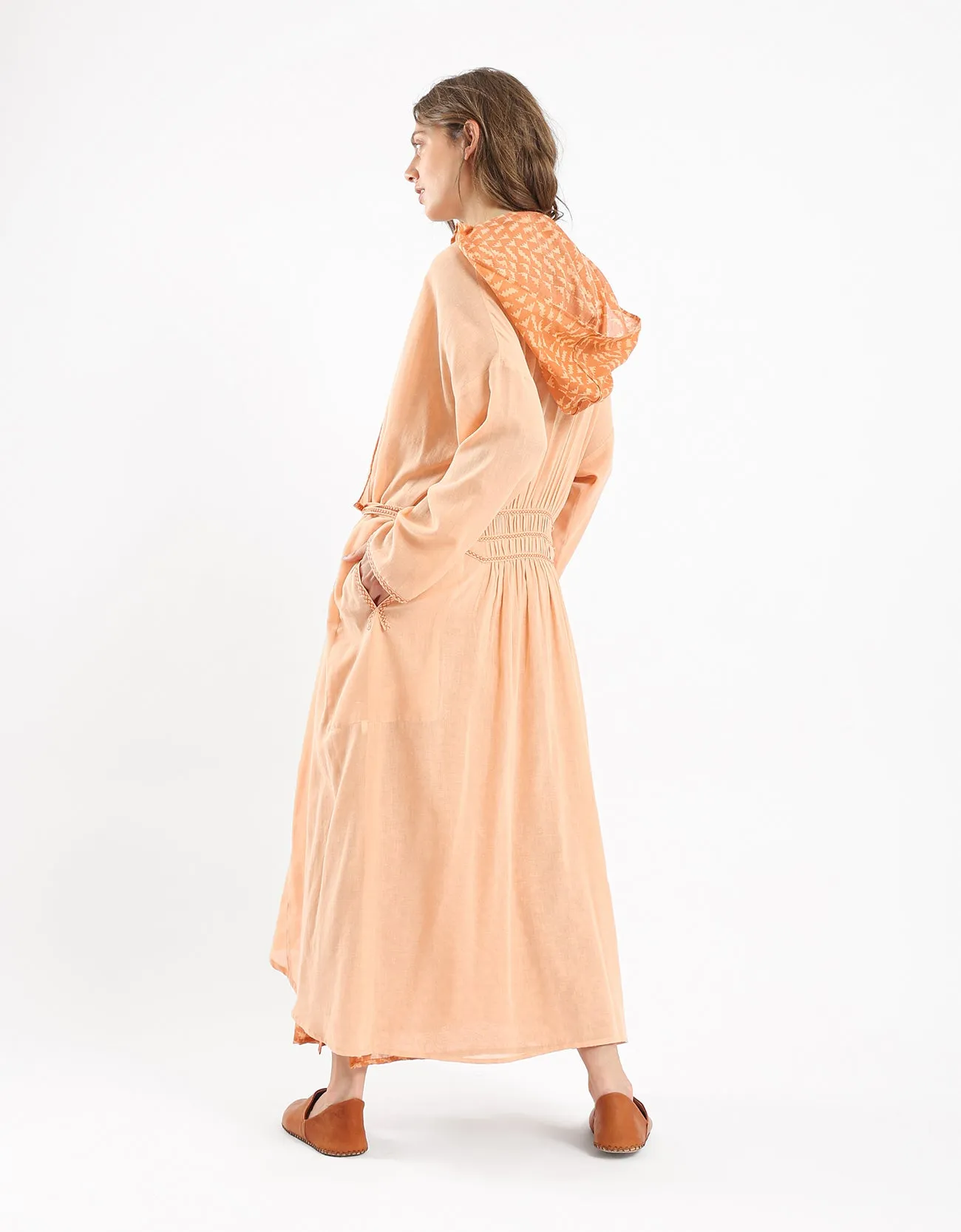 Long draped coat with decorative stitching details on the belt